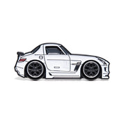 Metal enamel pin of a SLS AMG in white with black wheels with faded Lamley logo. In collaboration with the Lamley Group.