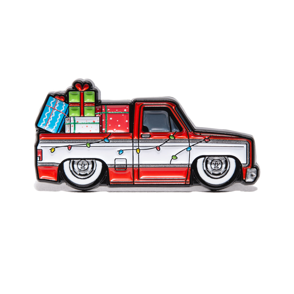 Illustration of a red and white 1975 Chevrolet C-10 with Christmas lights and presents on a white background