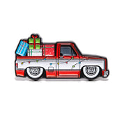 Illustration of a red and white 1975 Chevrolet C-10 with Christmas lights and presents on a white background