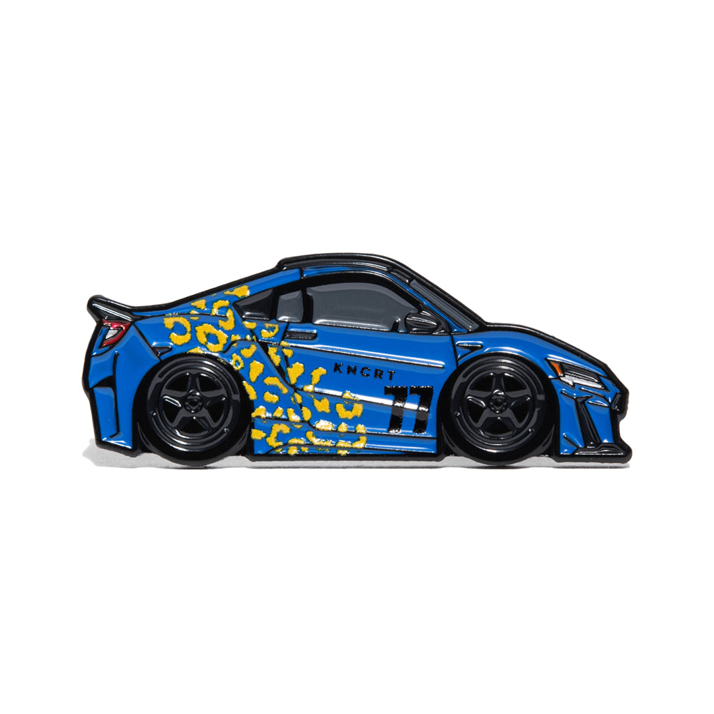 Metal enamel pin of a 2021 Acura NSX in blue with yellow leopard print and black wheels.