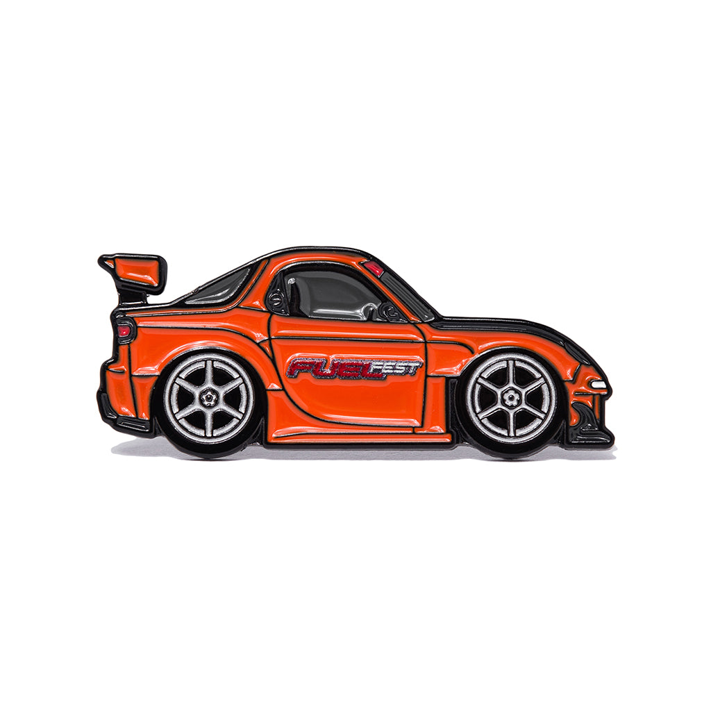 Metal enamel pin of a wide body FD RX7 in orange with silver six spoke wheels with Fuel Fest logo.