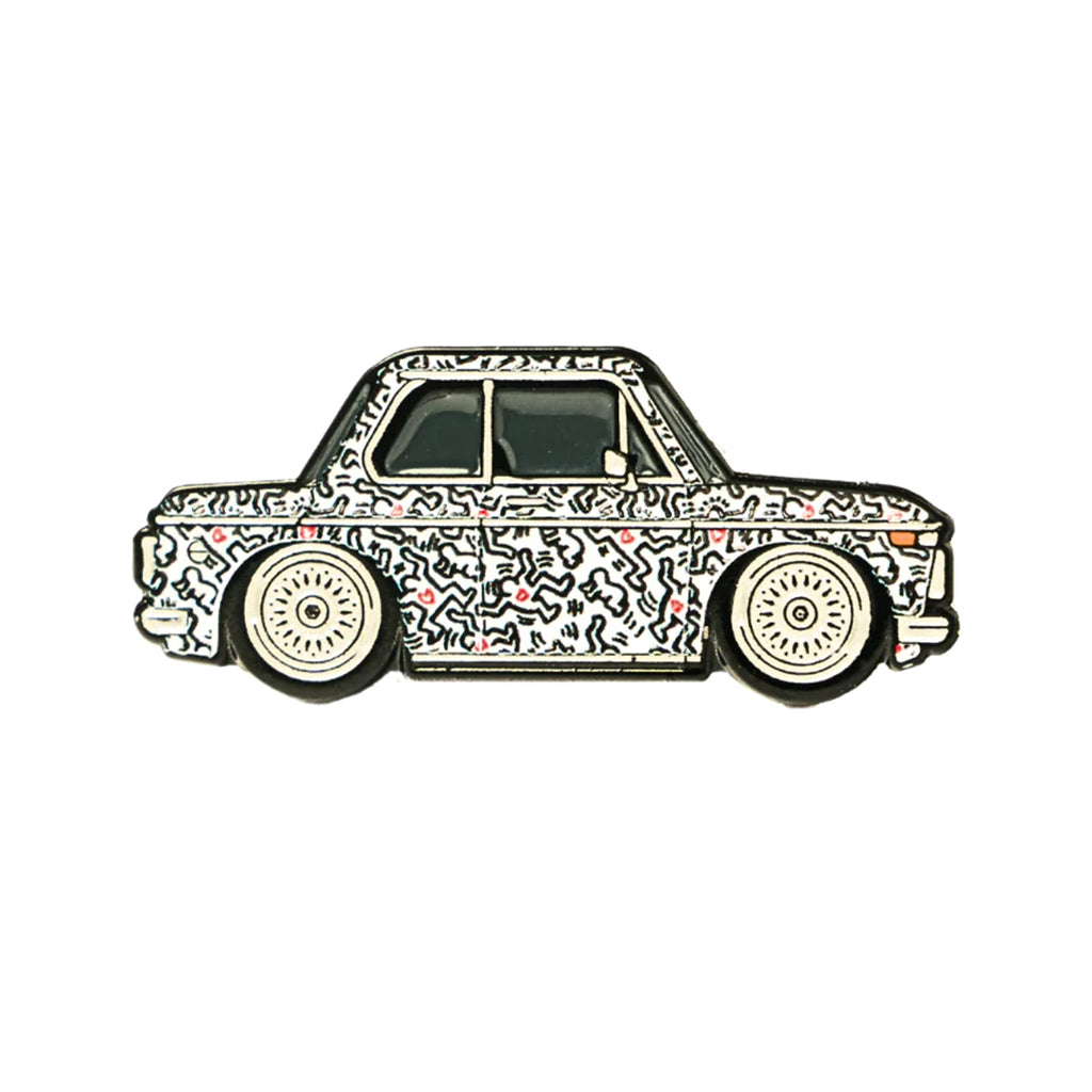 A soft enamel lapel pin depicting a BMW 2002 with a Keith Haring inspired livery.