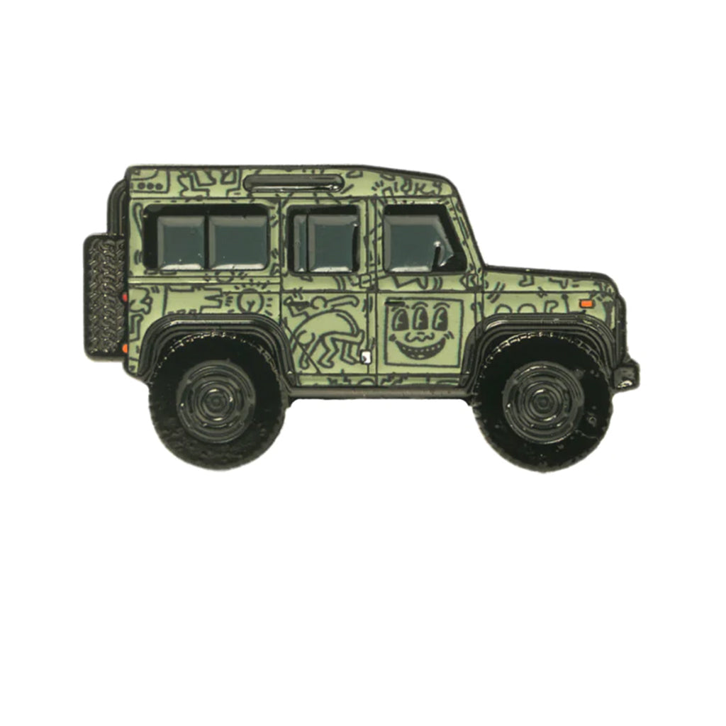 A soft enamel lapel pin depicting a Land Rover Defender with a Keith Haring inspired livery.