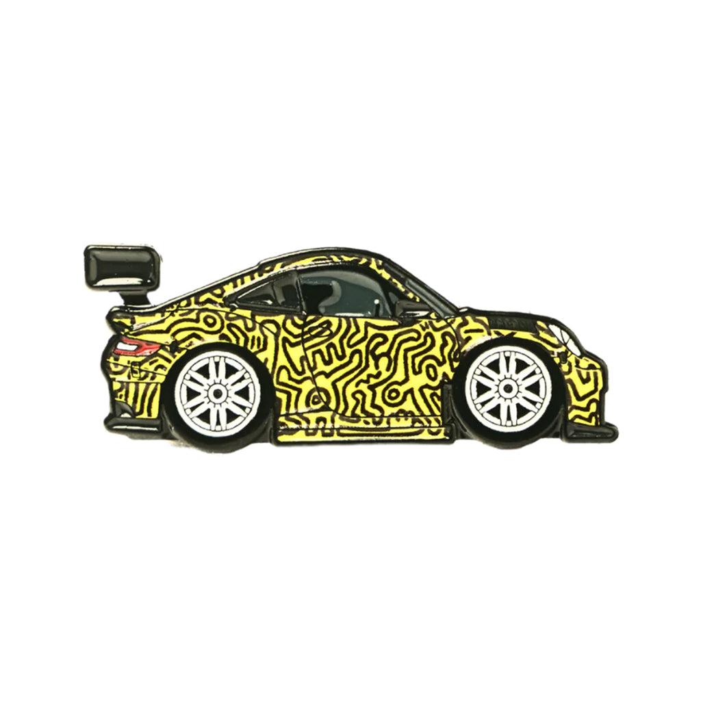 A soft enamel lapel pin depicting a Porsche GT3 with a Keith Haring inspired livery.
