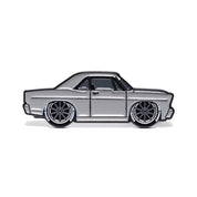 Metal enamel pin of 1967 Ford Galaxie Fastback built by Shaun Dickie at Americarna Workshop Services in grey with dark grey wheels.