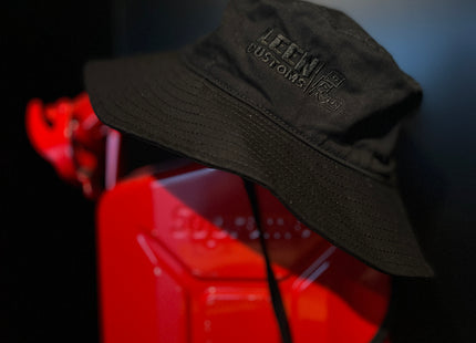Black Leen Customs wide brim bucket hat placed on a red Supreme Wavian 5L Jerry Can 